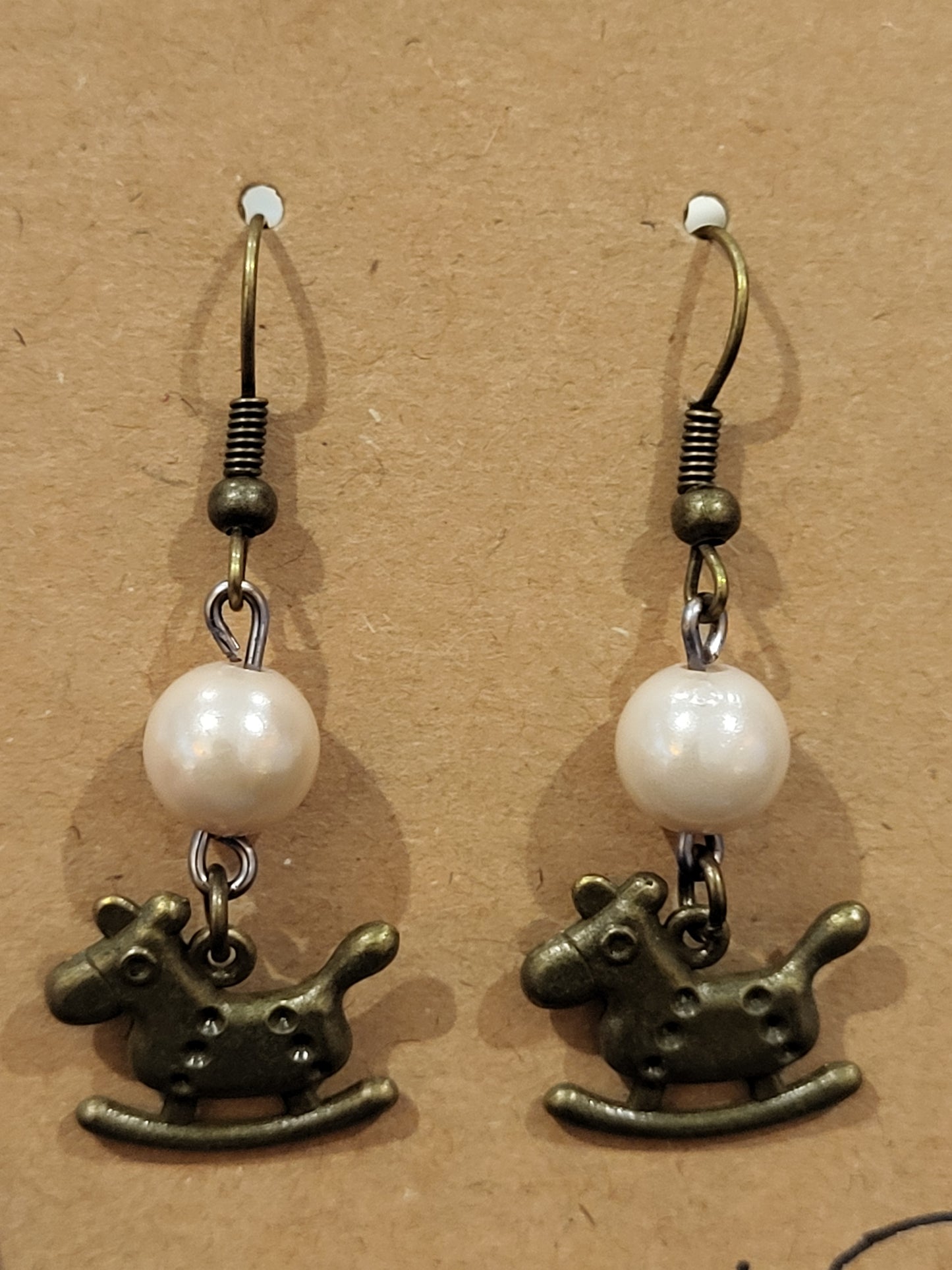Handmade simple beige bead earrings with rocking horse charm