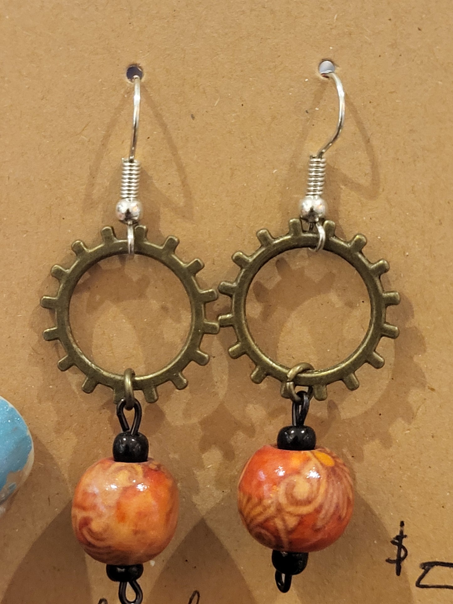 Handmade ornate red bead and sun gear earrings top alt