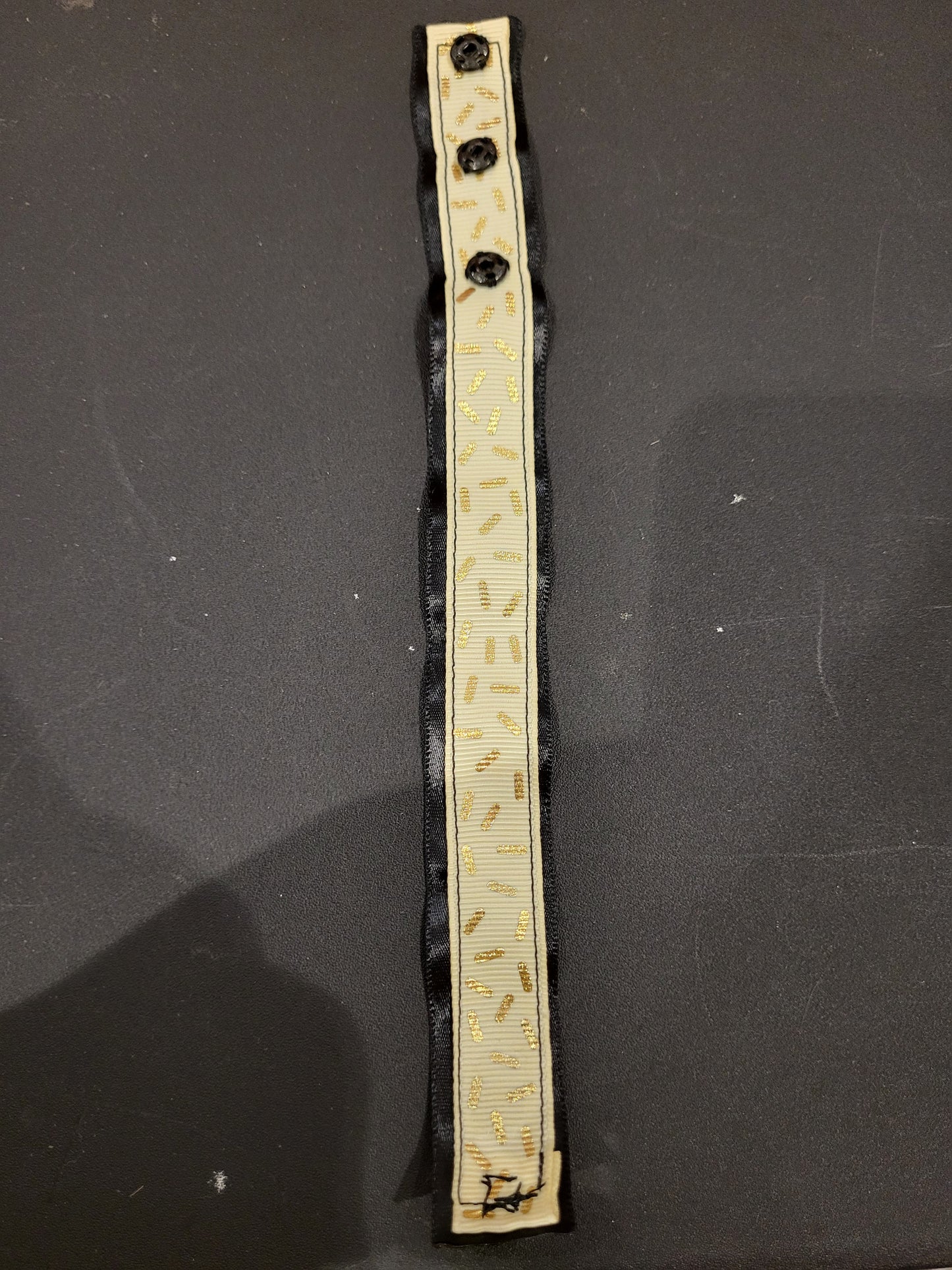 Handmade gold sprinkle fabric cuff bracelet with black ribbon backing