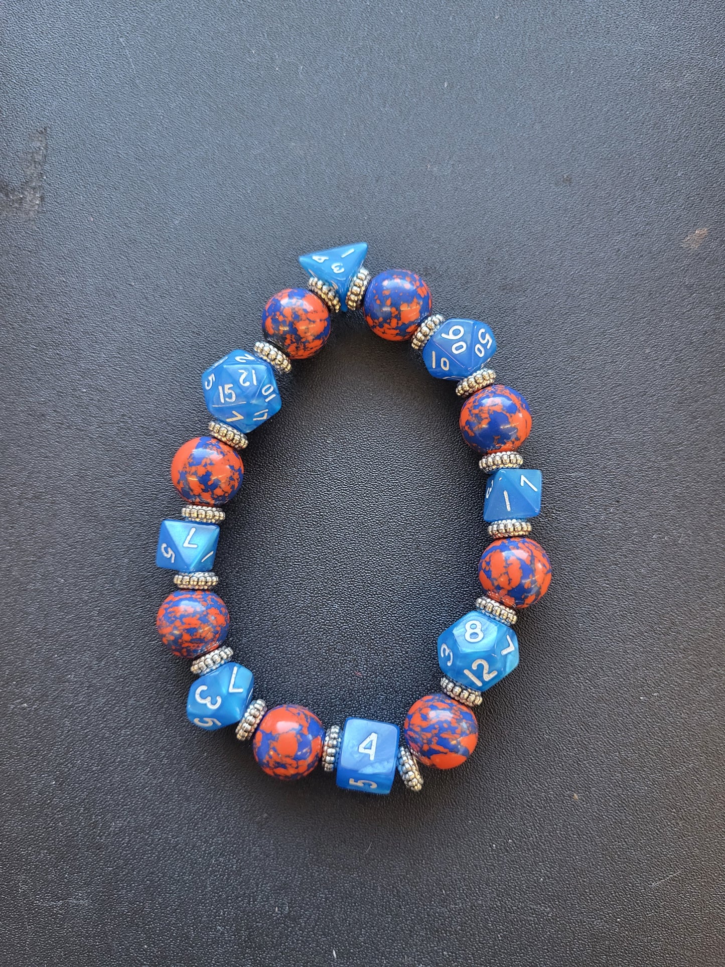 Orange and blue splotchy bead and blue dice stretch bracelet