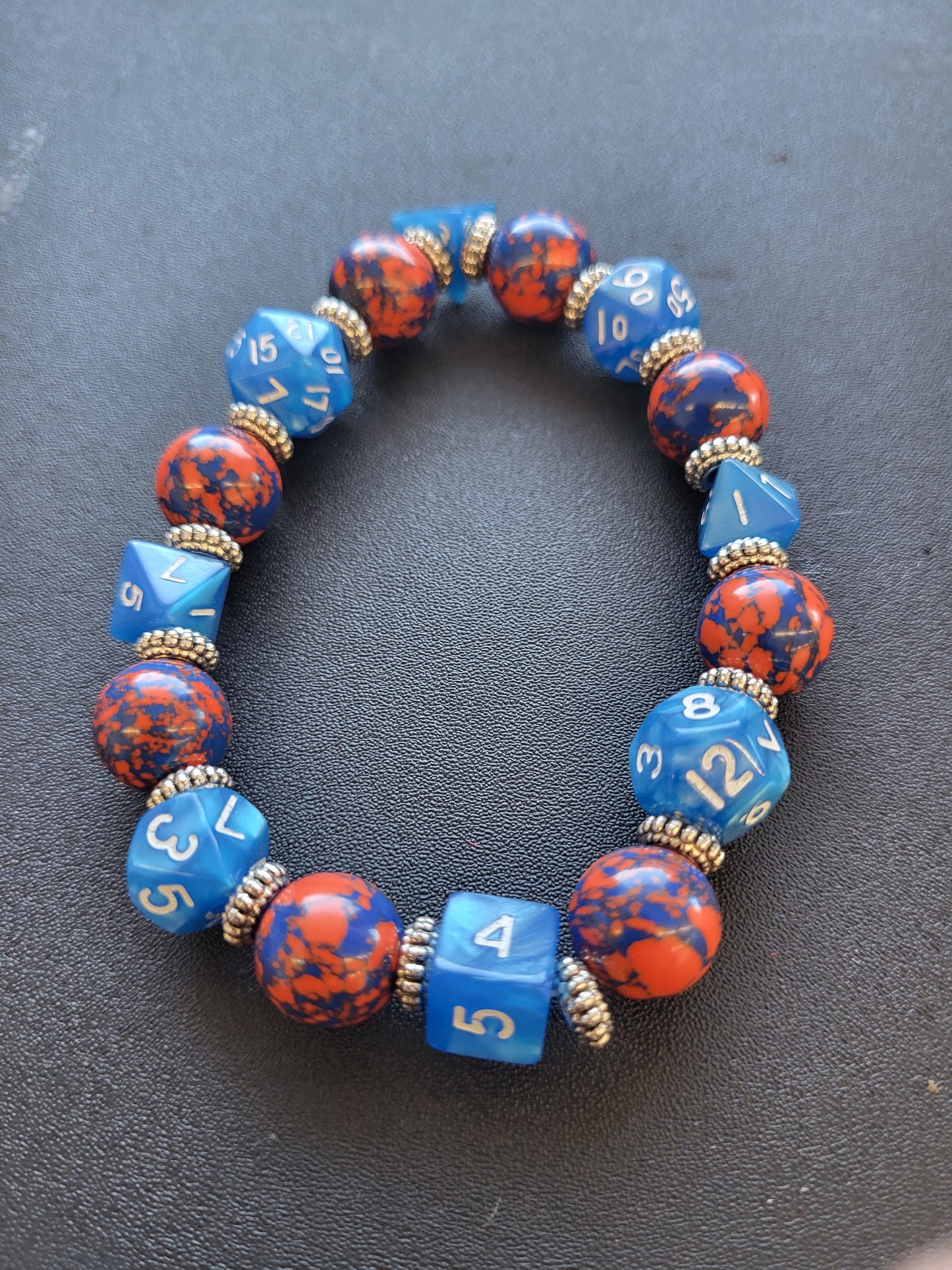 Orange and blue splotchy bead and blue dice stretch bracelet