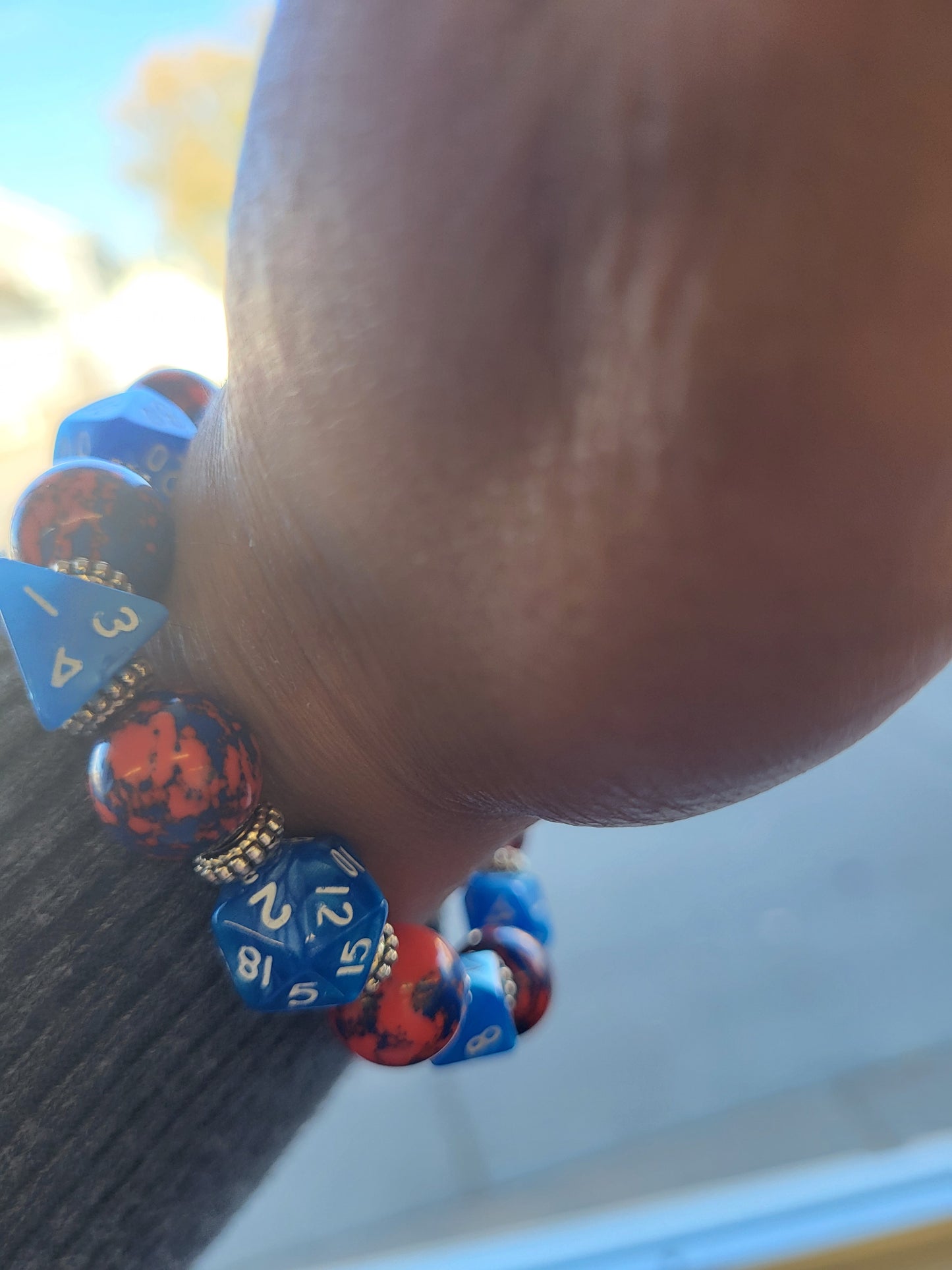 Orange and blue splotchy bead and blue dice stretch bracelet